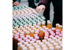 Image A table filled with various bottles of juice, showcasing a colorful assortment of flavors from Innocent.